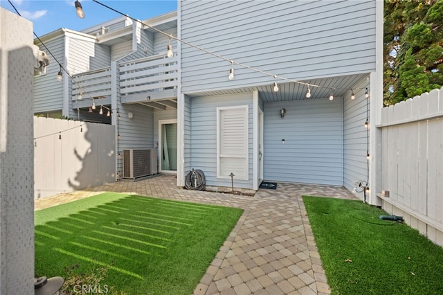 rear view of property featuring a patio, a lawn, and central air condition unit