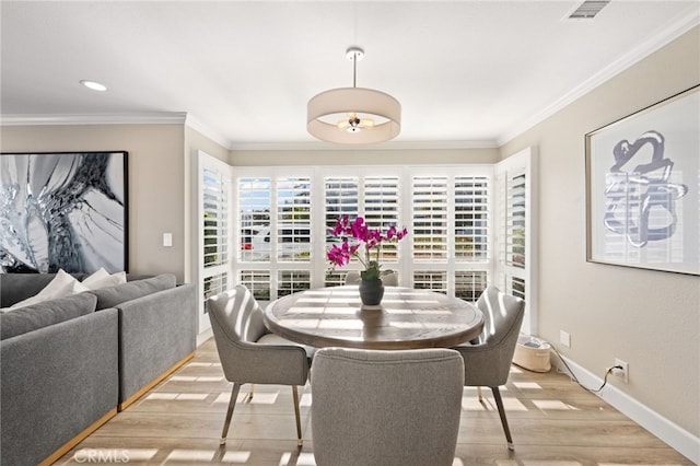 dining space featuring crown molding and light hardwood / wood-style floors