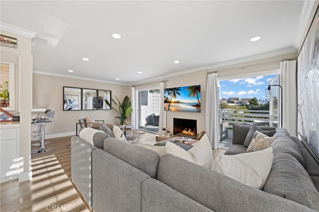 living room featuring ornamental molding, plenty of natural light, and light hardwood / wood-style flooring