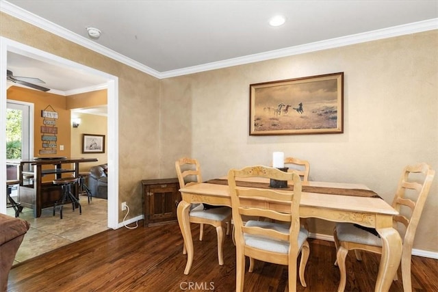 dining space featuring dark hardwood / wood-style flooring, crown molding, and ceiling fan