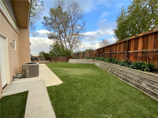 view of yard with central AC unit and a patio area