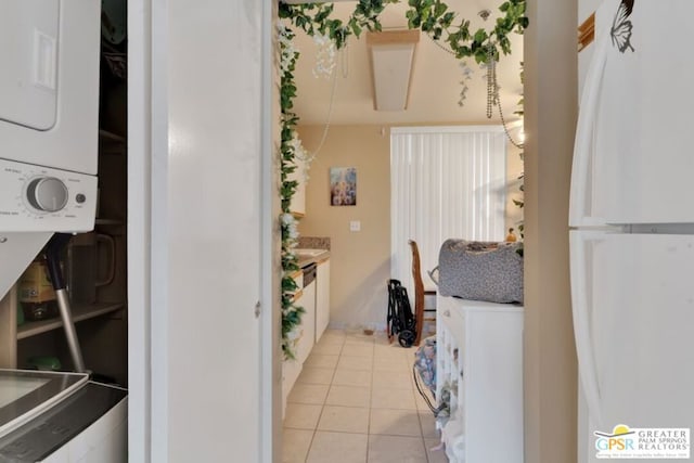 kitchen with white cabinetry, light tile patterned flooring, and white fridge