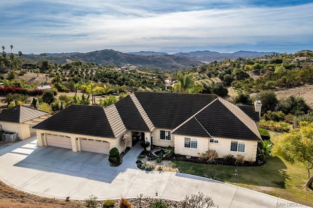 view of front of house featuring a mountain view, a garage, and a front lawn