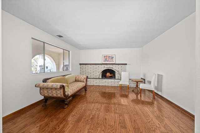 sitting room with hardwood / wood-style floors and a fireplace