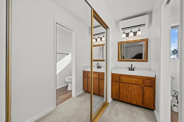 bathroom with vanity, toilet, and a wall mounted AC