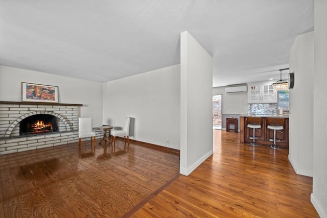 sitting room featuring dark hardwood / wood-style flooring, a wall mounted air conditioner, and a fireplace