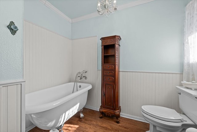 bathroom with toilet, a tub, ornamental molding, a notable chandelier, and hardwood / wood-style flooring