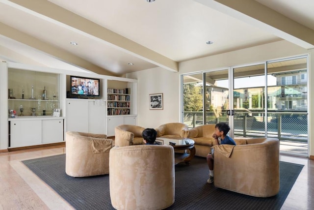 living room with beam ceiling, built in features, and hardwood / wood-style flooring