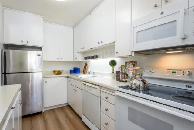 kitchen with dark hardwood / wood-style floors, sink, white cabinets, and white appliances