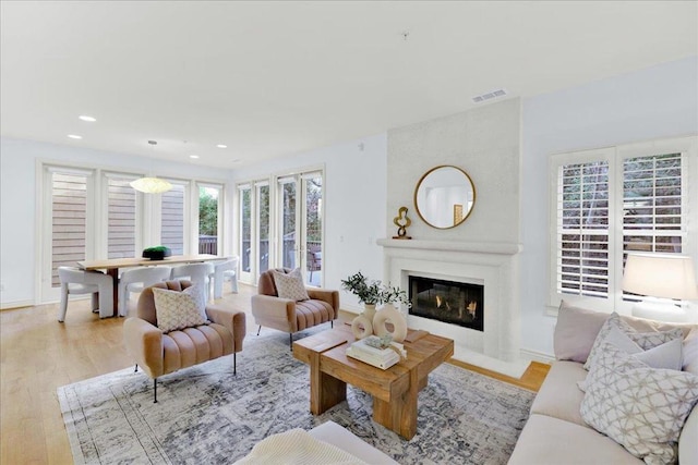 living room with a fireplace and light wood-type flooring