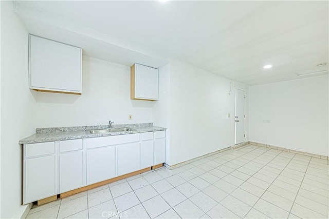 kitchen featuring white cabinetry and sink