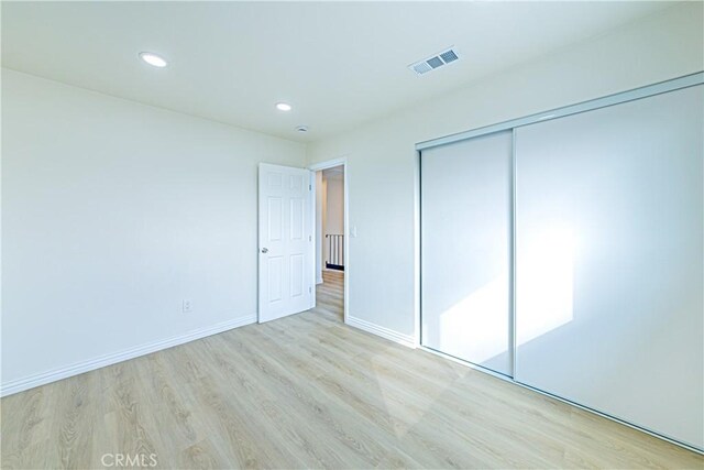 unfurnished bedroom featuring a closet and light hardwood / wood-style flooring