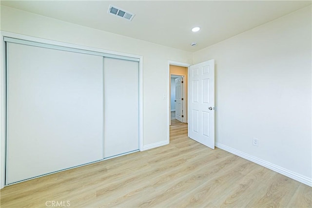 unfurnished bedroom with light hardwood / wood-style floors and a closet