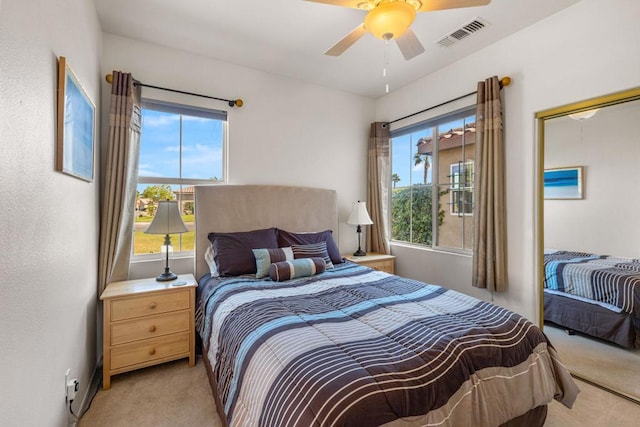 bedroom featuring multiple windows, light carpet, and ceiling fan