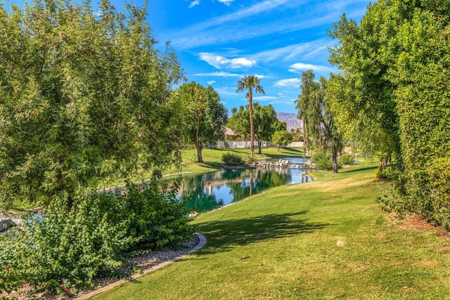 view of community with a lawn and a water view