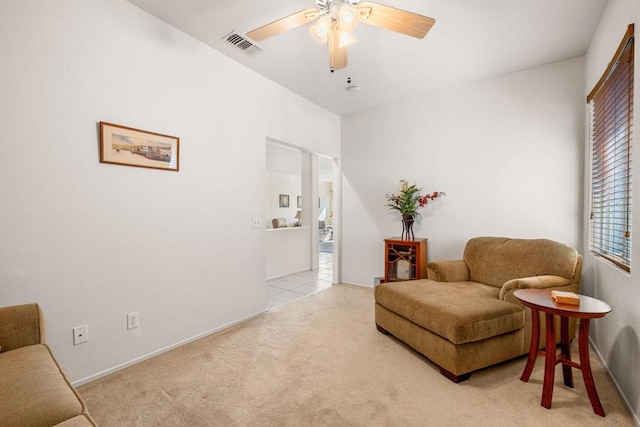 living area with ceiling fan and light colored carpet