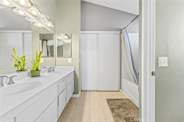 bathroom featuring shower / bath combo, hardwood / wood-style floors, and vanity