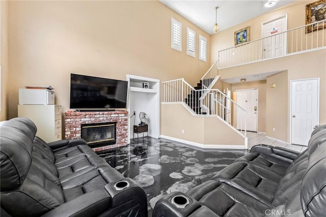 living room with a towering ceiling and a fireplace