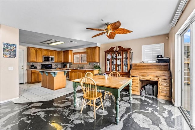 tiled dining area with sink and ceiling fan