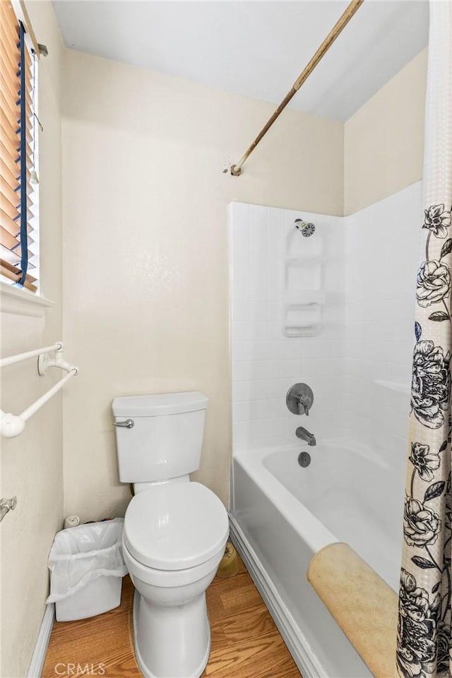 bathroom with hardwood / wood-style floors, toilet, and shower / bath combo