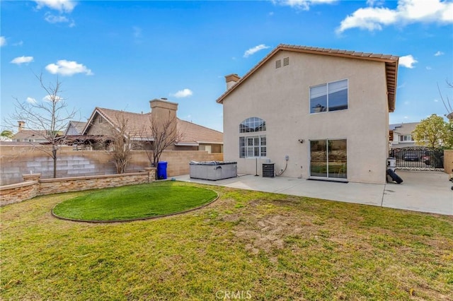 rear view of house featuring a yard, a hot tub, central AC unit, and a patio area