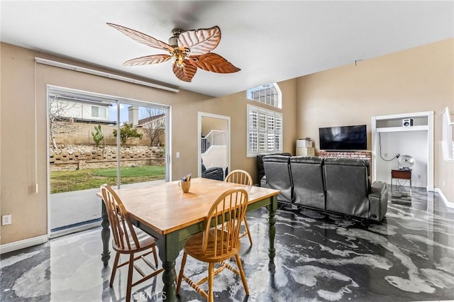 dining space featuring a wealth of natural light, concrete floors, and ceiling fan