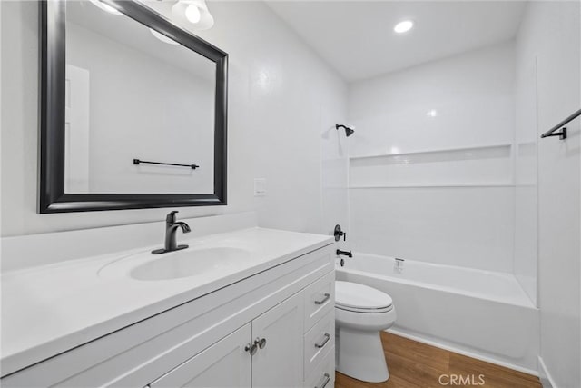 full bathroom with wood-type flooring, bathing tub / shower combination, vanity, and toilet