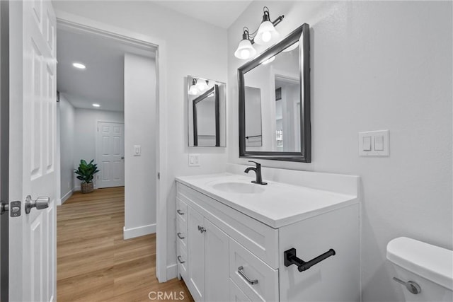 bathroom with vanity, hardwood / wood-style flooring, and toilet