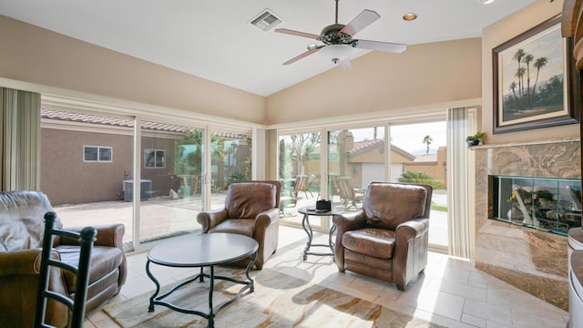 sunroom with vaulted ceiling, ceiling fan, and a fireplace