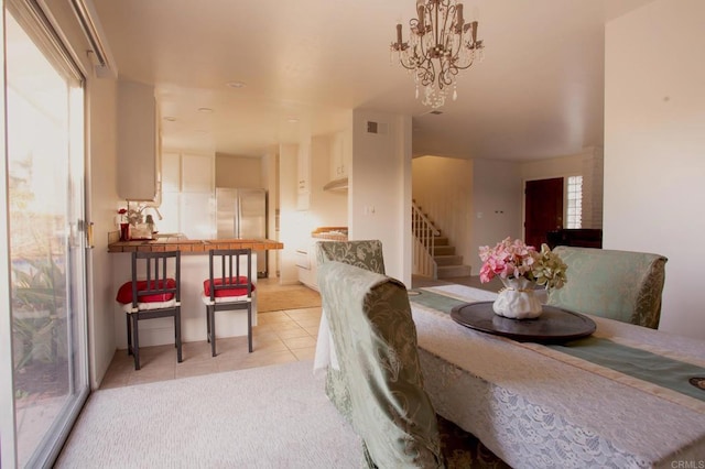 dining area with light tile patterned floors, a notable chandelier, and sink