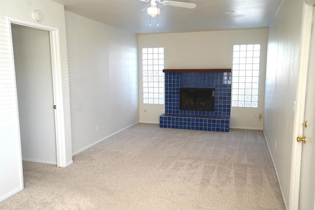 unfurnished living room with a fireplace, light colored carpet, and plenty of natural light