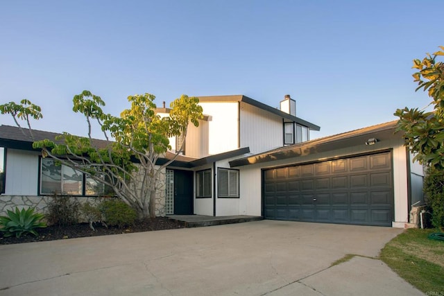 5934 Carnegie St, San Diego, CA 92122 - view of front of home featuring a garage, driveway, and a chimney