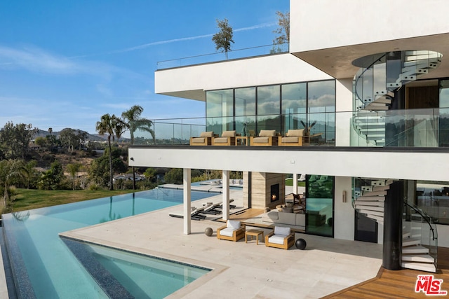 view of swimming pool with a patio and an outdoor fireplace