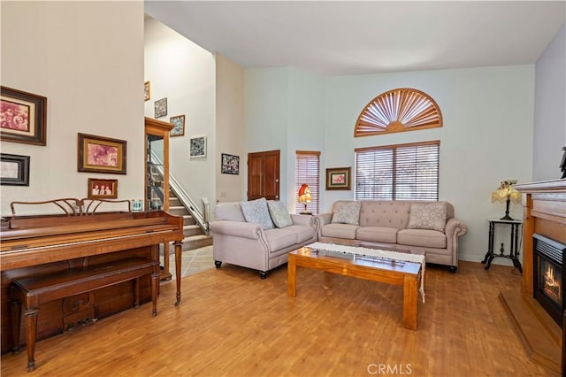 living room featuring a high ceiling and light wood-type flooring