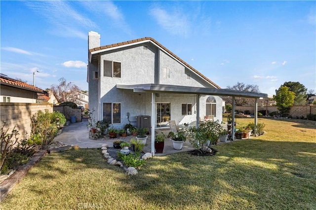 rear view of house featuring a yard and a patio