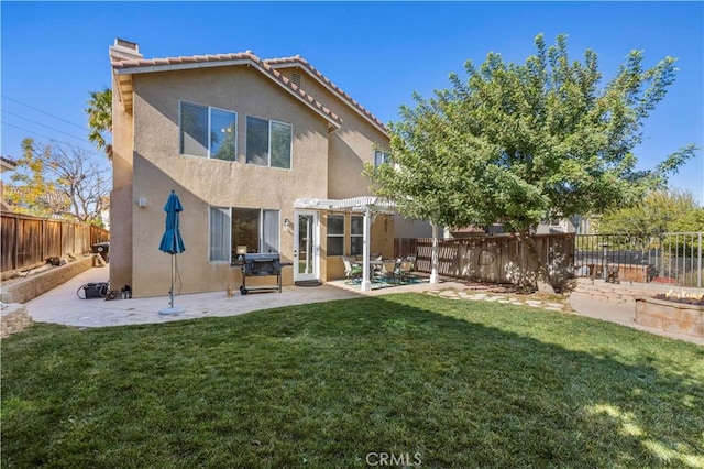 rear view of house featuring a pergola, a patio area, and a lawn