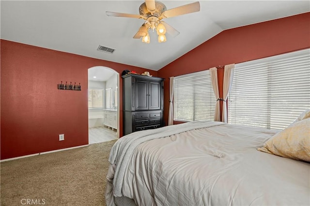 bedroom featuring ensuite bathroom, lofted ceiling, carpet floors, and ceiling fan