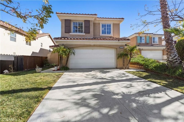 mediterranean / spanish house with a garage and a front yard