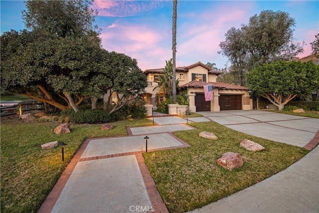 mediterranean / spanish-style house with a garage and a yard