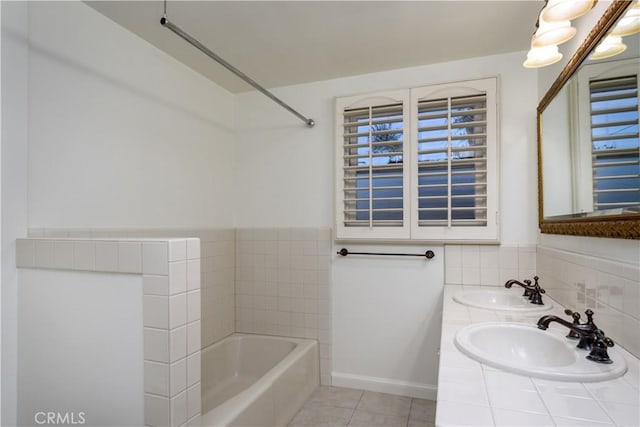 bathroom with tile patterned flooring, a bathing tub, and sink