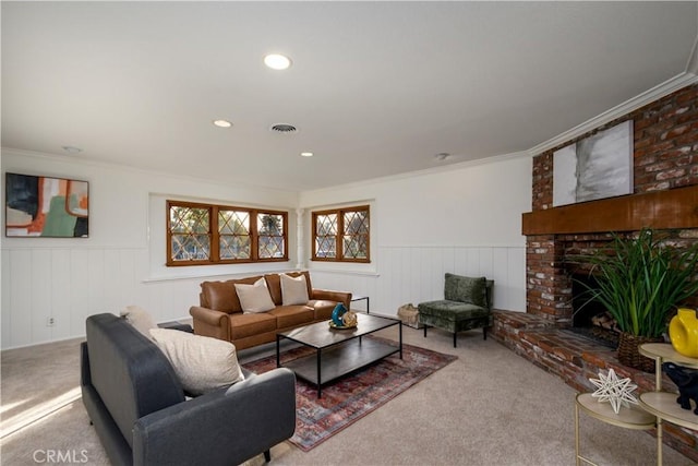 living room featuring crown molding, a fireplace, and carpet