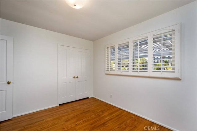 unfurnished bedroom featuring hardwood / wood-style floors and a closet