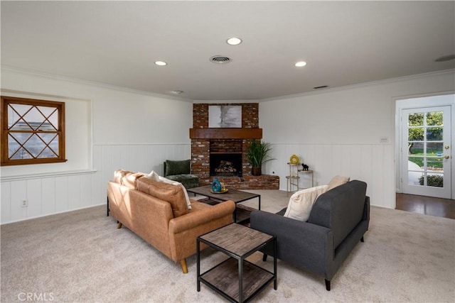 living room featuring crown molding, a fireplace, and light carpet