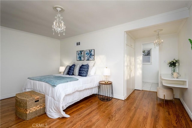 bedroom featuring crown molding, hardwood / wood-style floors, and a notable chandelier