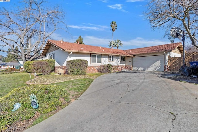 ranch-style home featuring a garage and a front lawn