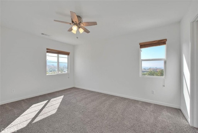 carpeted spare room featuring ceiling fan