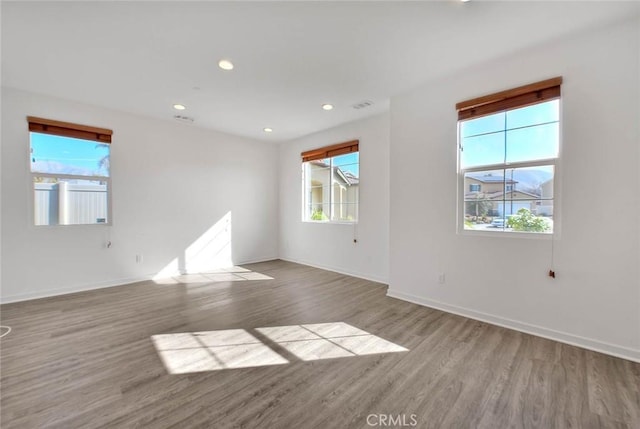 unfurnished room with light hardwood / wood-style flooring and a healthy amount of sunlight