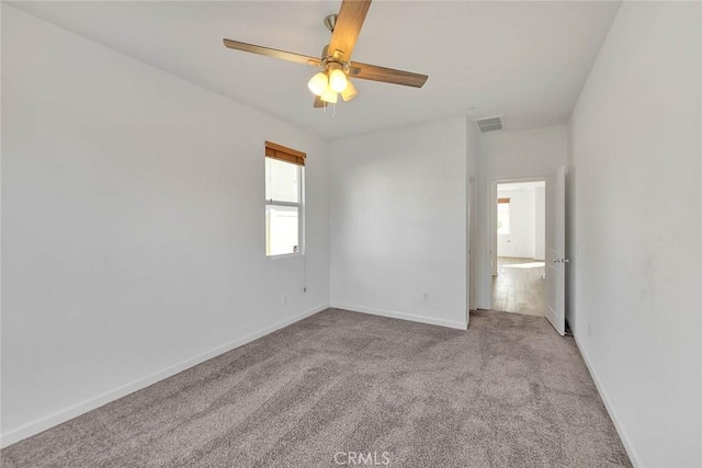 empty room featuring light colored carpet and ceiling fan