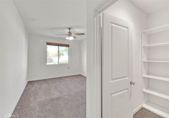 spare room featuring ceiling fan and carpet