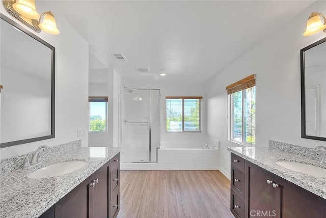 bathroom with hardwood / wood-style flooring, shower with separate bathtub, and vanity